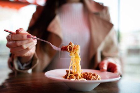 Foto de Mujer comiendo espaguetis en un café - Imagen libre de derechos