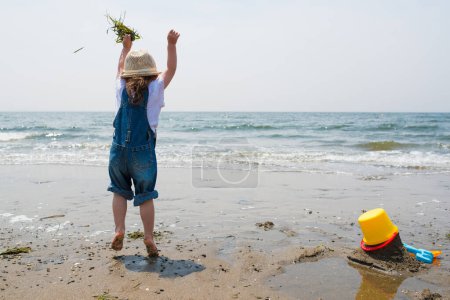 Téléchargez les photos : Fille jouer dans la mer côte - en image libre de droit