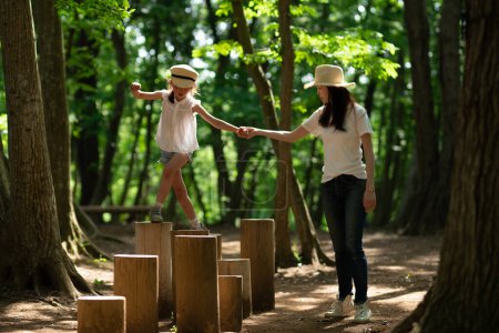 Photo for Mother and daughter playing in forest park - Royalty Free Image