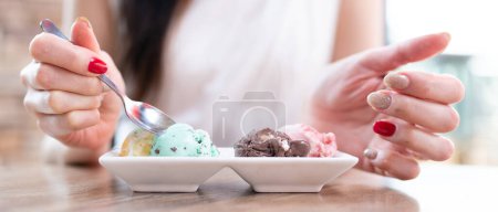 Téléchargez les photos : Femme mangeant de la glace dans un café - en image libre de droit
