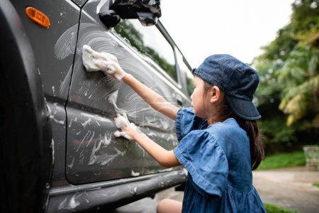 Téléchargez les photos : Fille laver une voiture avec une éponge - en image libre de droit