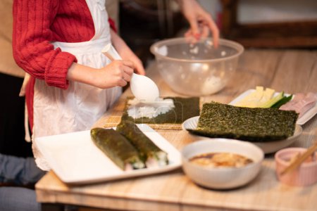 Photo for Mother and daughter making sushi rolls - Royalty Free Image