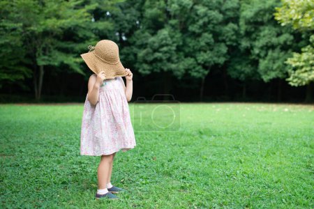 Téléchargez les photos : Une fille les yeux bandés avec un chapeau de paille - en image libre de droit