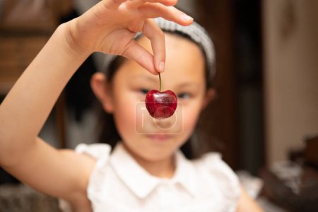Photo for Girl picking up with a cherry - Royalty Free Image