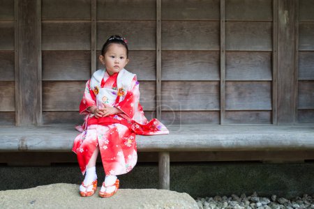 Téléchargez les photos : Petite fille en kimono japonais sur banc - en image libre de droit