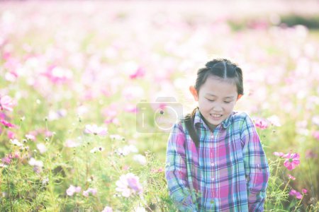 Photo for Girl smell the fragrance of flowers in the flower garden - Royalty Free Image