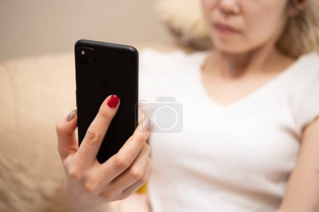 Foto de Mujer mirando un teléfono inteligente en la habitación - Imagen libre de derechos
