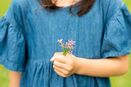 Foto de Niño sosteniendo una pequeña flor - Imagen libre de derechos