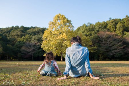 Téléchargez les photos : Mère et fille se relaxent dans le parc d'automne - en image libre de droit
