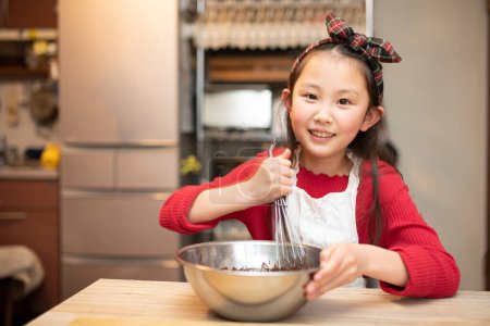 Photo for A girl making sweets in her kitchen - Royalty Free Image