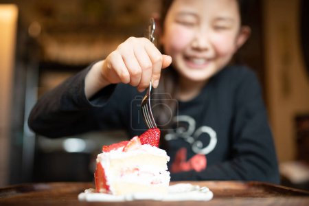 Photo for Girl eating homemade birthday cake - Royalty Free Image
