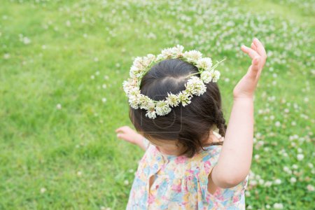 Téléchargez les photos : Fille jouer et porter une couronne de fleurs - en image libre de droit
