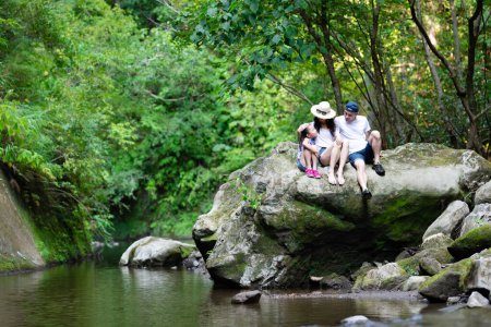 Téléchargez les photos : Père, mère et fille jouant dans le ruisseau de montagne - en image libre de droit