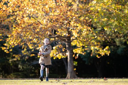 Téléchargez les photos : Fille jouant dans le parc d'automne - en image libre de droit