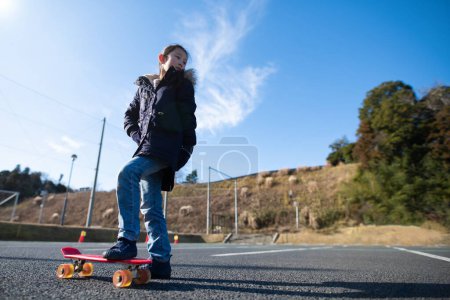 Téléchargez les photos : Fille jouer sur un skateboard - en image libre de droit