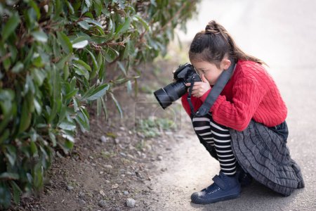 Photo for A girl taking a picture with a single-lens reflex camera - Royalty Free Image