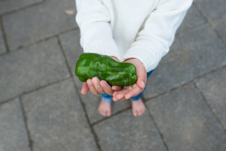 Niño con una pimienta en las manos