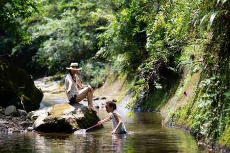 Téléchargez les photos : Mère et fille jouent dans le ruisseau de montagne - en image libre de droit