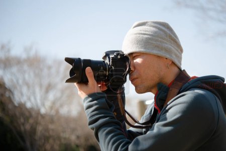 Man take photos with a single-lens reflex camera