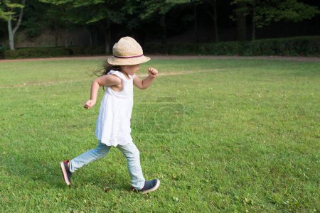 Téléchargez les photos : Petite fille jouant sur la pelouse en été. - en image libre de droit