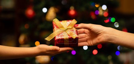 Photo for Parent and child handing Christmas gifts - Royalty Free Image