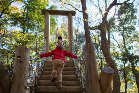 Téléchargez les photos : Jeune fille sur l'aire de jeux dans le parc d'automne - en image libre de droit