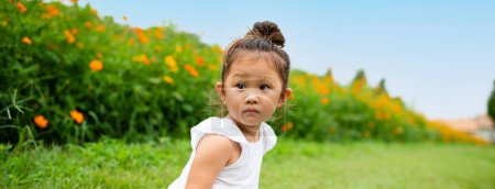 Téléchargez les photos : Portrait d'une belle petite fille dans le jardin - en image libre de droit