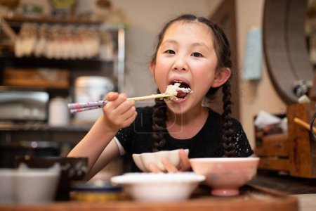 Photo for Portrait of a girl eating with chopsticks - Royalty Free Image