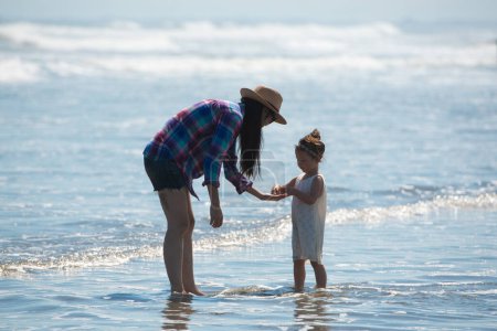 Mother and daughter playing on the beach