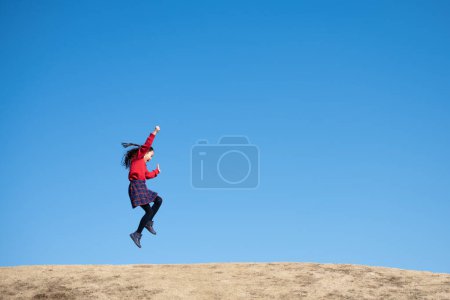 Téléchargez les photos : Fille sautant sous le ciel bleu - en image libre de droit
