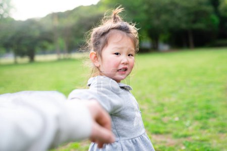 Photo for Toddler girl pulling parents' hand - Royalty Free Image