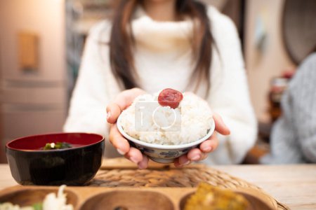 Foto de Una mujer comiendo arroz en un tazón - Imagen libre de derechos
