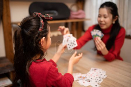 Photo for Mother and daughter playing card games at home - Royalty Free Image