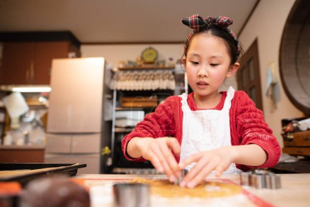 Téléchargez les photos : Fille faire des cookies à la maison - en image libre de droit