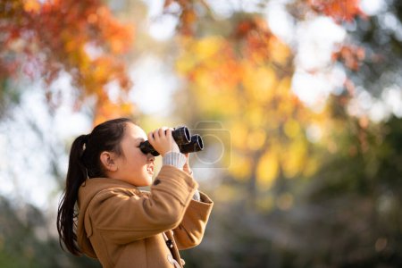 Foto de Chica usando prismáticos en el bosque de otoño - Imagen libre de derechos