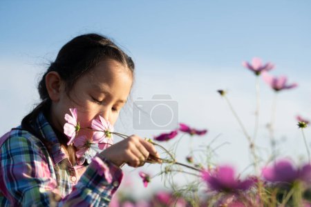 Photo for Girl smell the fragrance of flowers in the flower garden - Royalty Free Image