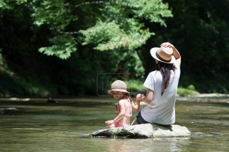 Photo for Mother and daughter playing in the river - Royalty Free Image