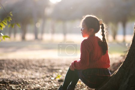 Téléchargez les photos : Fille assise sur un tronc d'arbre - en image libre de droit