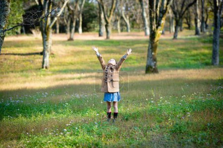 Photo for Girl opens arms in the autumn forest - Royalty Free Image