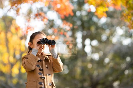 Foto de Chica usando prismáticos en el bosque de otoño - Imagen libre de derechos