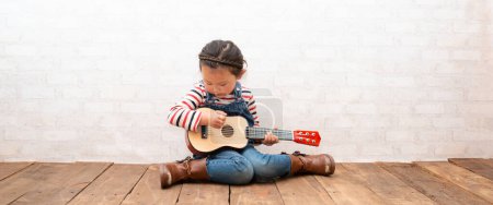 Photo for Little girl playing the guitar - Royalty Free Image