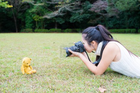 Téléchargez les photos : Femme qui prend la photo de l'ours en peluche - en image libre de droit
