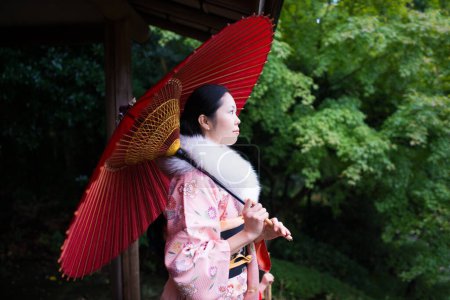 Photo for Beautiful Japanese woman holding an umbrella wearing a kimono - Royalty Free Image