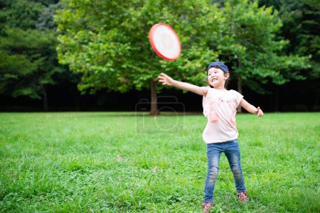 Téléchargez les photos : Petite fille jetant un frisbee - en image libre de droit