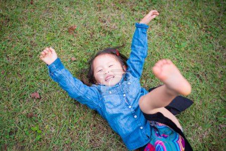 Téléchargez les photos : Fille s'amuser sur herbe verte - en image libre de droit