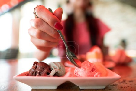Téléchargez les photos : Femme mangeant de la glace dans un restaurant - en image libre de droit