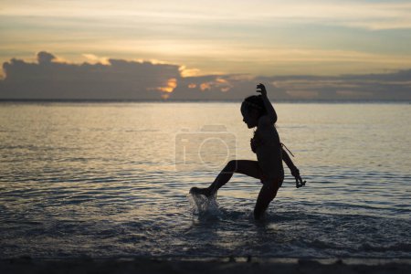 Photo for Beautiful young asian girl  on the beach at sunrise - Royalty Free Image