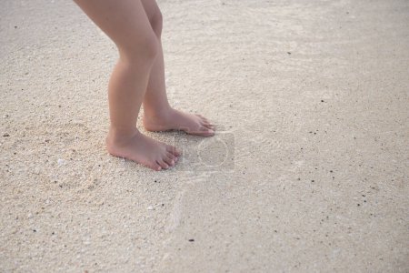 Photo for Child's feet playing on the beach - Royalty Free Image