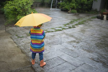 Photo for Girl wearing a raincoat with umbrella - Royalty Free Image