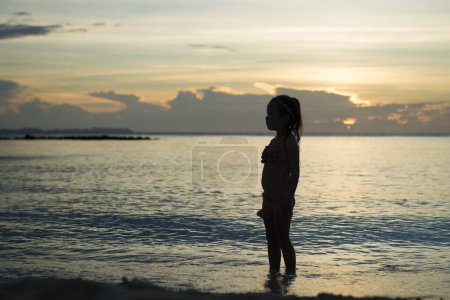 Photo for Silhouette of cute little asian girl  in bikini at sea - Royalty Free Image